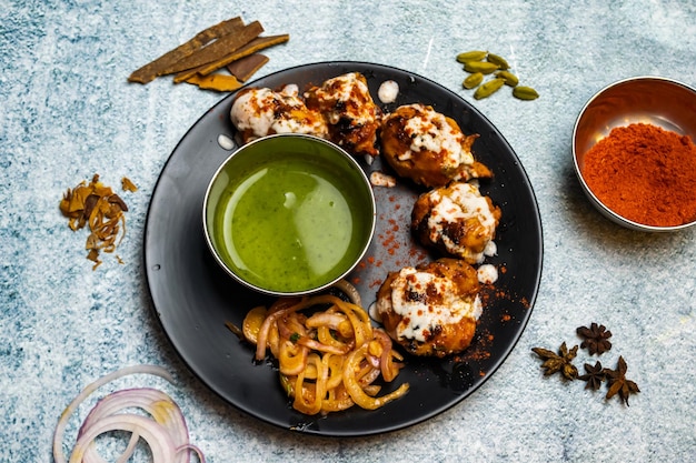 Spicy bbq Chicken tikka boti Kebab with chili sauce served in a dish isolated on grey background top view of bangladesh food