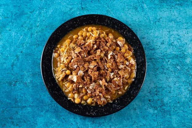 Spicy Chana chat masala chotpoti in a black dish isolated on background top view of indian bangali and pakistani food chat pata food