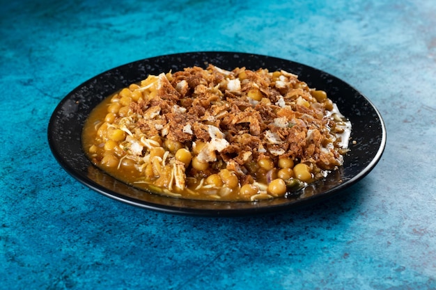 Spicy Chana chat masala chotpoti in a black dish isolated on background top view of indian bangali and pakistani food chat pata food