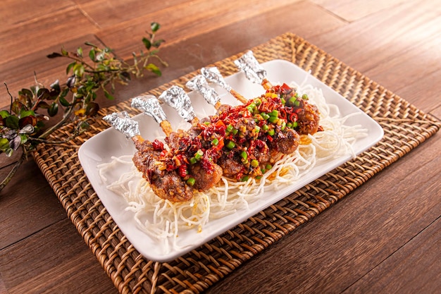 Spicy chili Cumin Pork Knuckle served dish isolated on wooden table top view of Hong Kong food