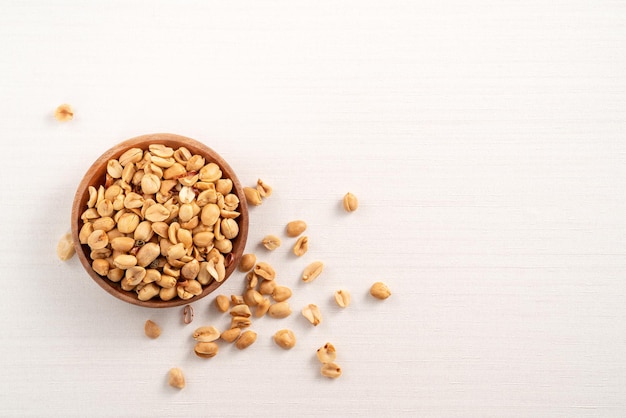 Spicy flavored peanut kernel in a bowl on white table background