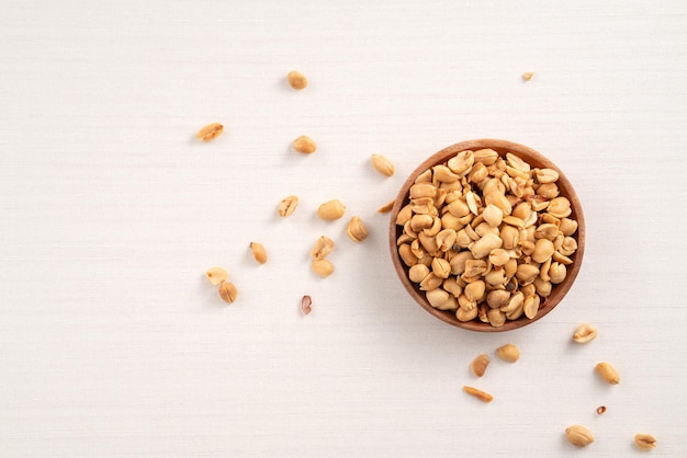 Spicy flavored peanut kernel in a bowl on white table background