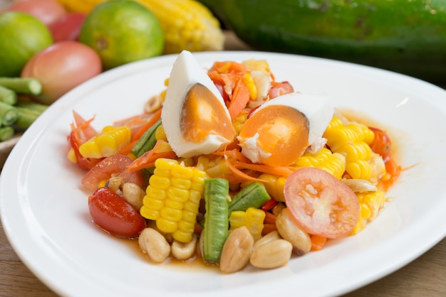 spicy fruit salad with salted egg in white plate 