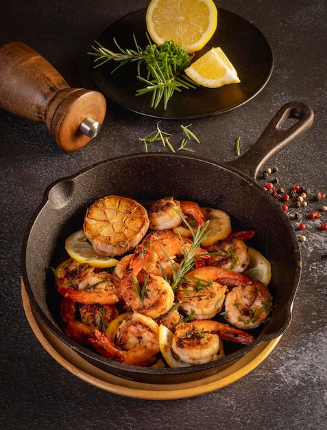 Spicy garlic chilli Prawns Shrimps on frying pan with lemon and cilantro