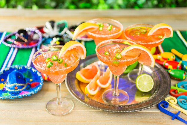 Spicy grapefruit margarita on ice in margarita glasses on the table in the garden.