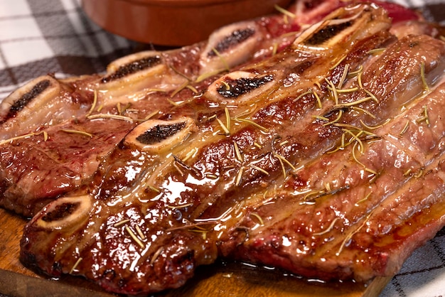 Spicy grilled spare ribs on cutting board close up