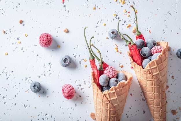 Spicy ice cream in cone with chilli and fruits