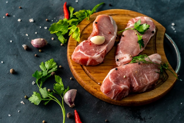 Spicy raw meat on a wooden slicing or cutting board, put a salt on an uncooked meats