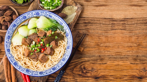 Spicy red soup beef noodle in a bowl on wooden table