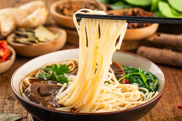 Spicy red soup beef noodle in a bowl on wooden table