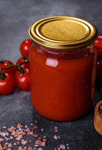 Photo spicy sweet tomato sauce with garlic pepper and herbs in a glass jars