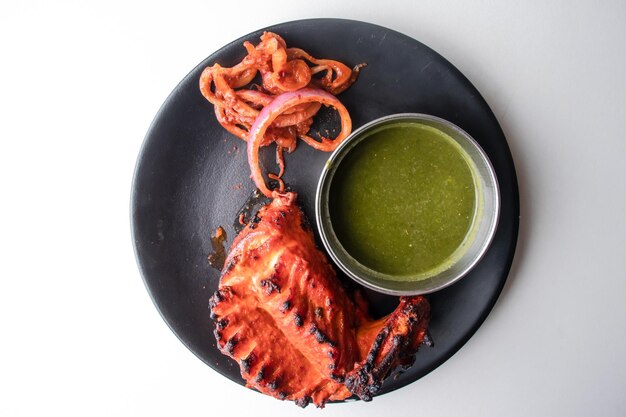 Spicy tandoori chicken Lal Badsha with chili sauce served in a dish isolated on grey background top view of bangladesh food