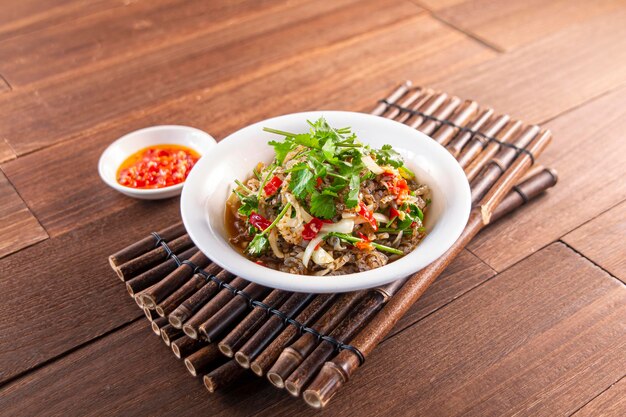 Spicy Wild Pepper Fresh Fish Skin served dish isolated on wooden table top view of Hong Kong food