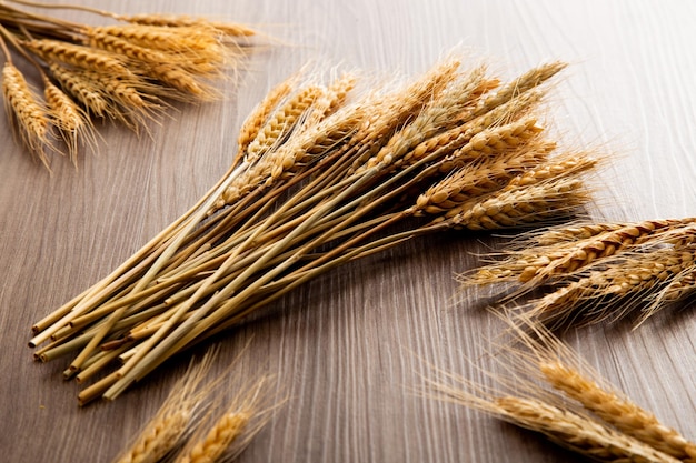 Spikelets of wheat on old wooden table background