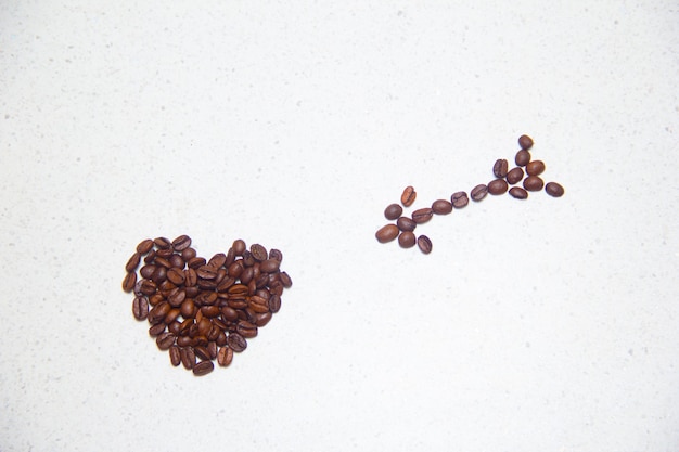 Spilled coffee beans. Coffee in the form of hearts. Coffee beans on the table