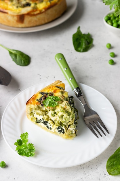 Spinach and green pea quiche, tart or pie with ingredients for baking. 