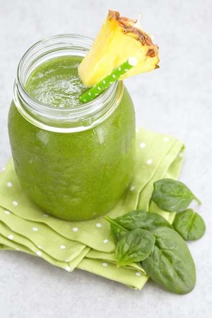 Spinach green smoothie topped with a pineapple slice