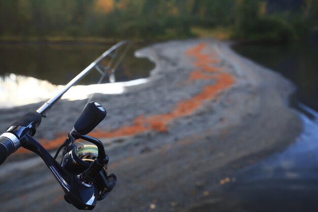 spinning reel in hand fishing nature, abstract background, hobby vacation man