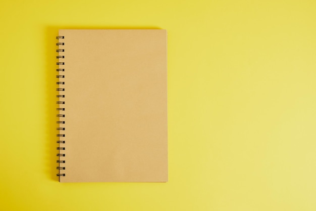 Spiral sketchbook with brown kraft sheets on yellow background