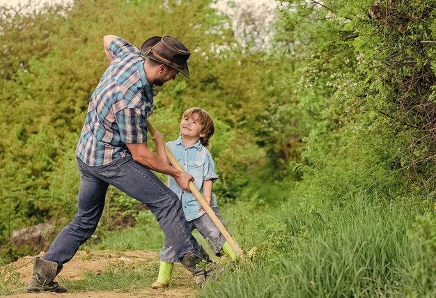 Spirit of adventures Adventure hunting for treasures Little helper in garden Cute child in nature having fun cowboy dad Find treasures Little boy and father with shovel looking for treasures