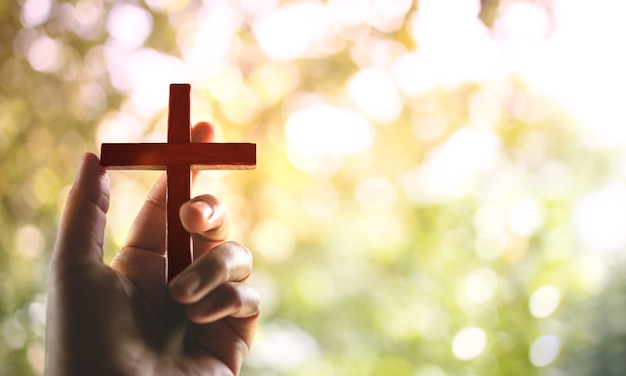 Spirituality and Religion Concept, Person Holding Christian Cross to Making Pray Outdoors. Believe and Faith for Christian People