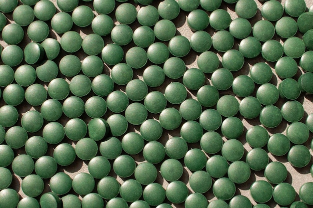 Spirulina pills background. Green pills. View from above