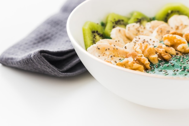 A spirulina smoothie bowl with banana, walnuts, kiwi and chia seeds