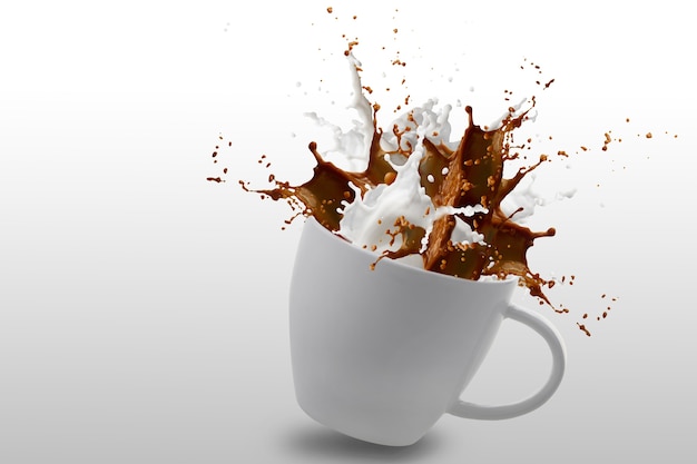 Splash of coffee and milk in white cup isolated on white with clipping path