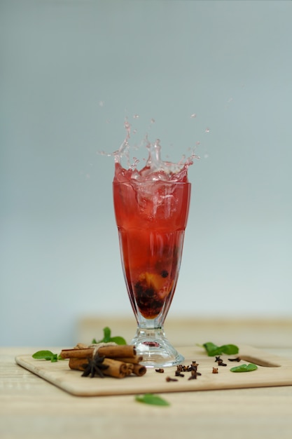 Splash Cup of hot vitamin tea on wooden table. winter hot seasonal drinks