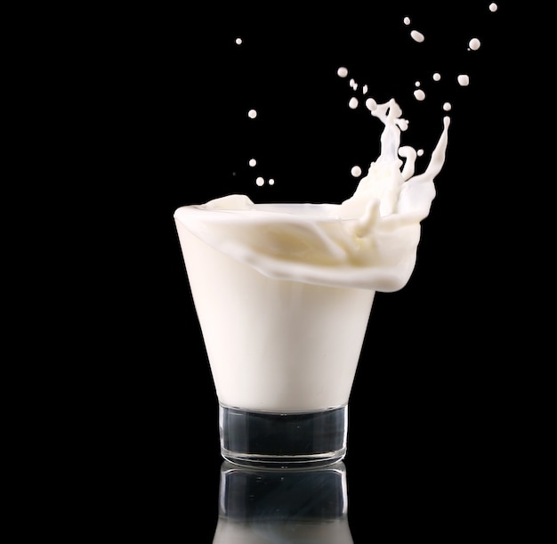 Splash in a glass with milk isolated on black