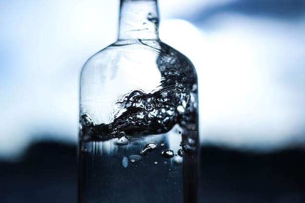 A splash of water in a bottle closeup on a dark light background Water details Water structure