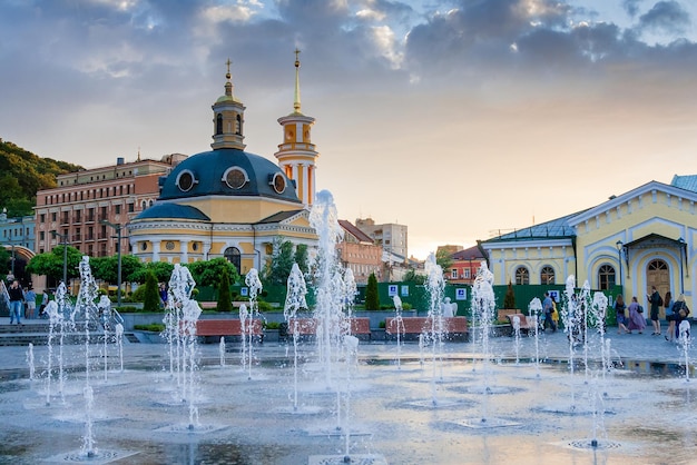 Splashes of a fountain against the backdrop of the city and a beautiful sunset