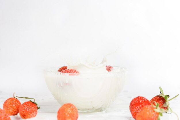 Splashes of milk from falling strawberries white background