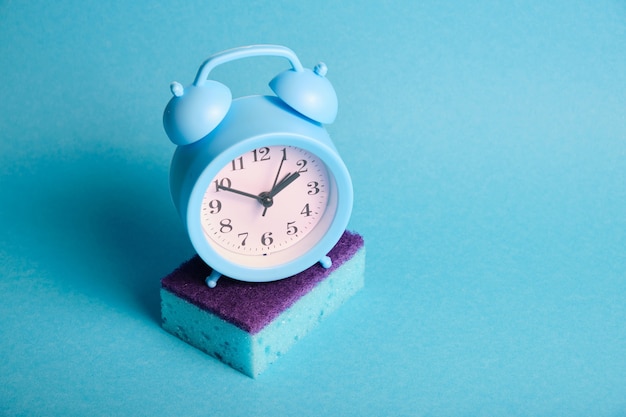 sponge and alarm clock spring cleaning concept