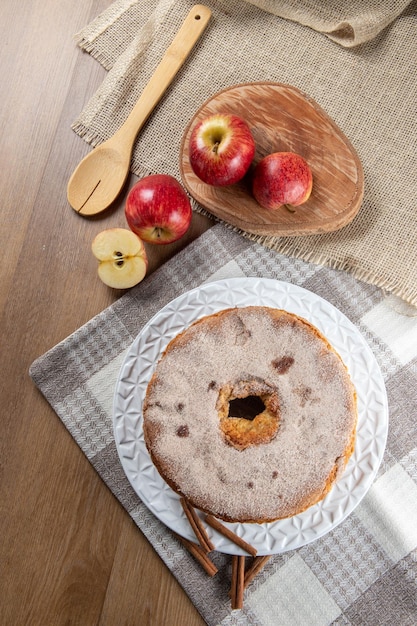 Photo sponge cake or chiffon cake with apples so soft and delicious sliced with ingredients cinnamon eggs flour apples on wooden table home bakery concept for background and wallpaper top view