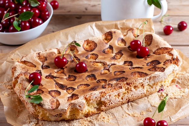 Sponge cake or chiffon cake with cherries so soft and delicious with ingredients on wooden table Homemade bakery concept for background and wallpaper