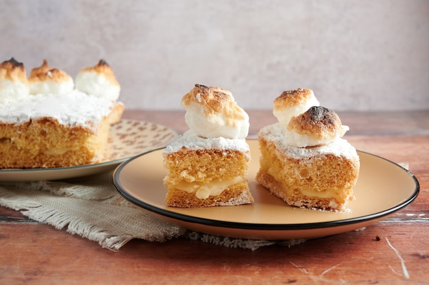 Sponge cake filled with cream and meringue on top. selective focus