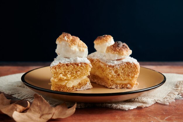 Sponge cake filled with cream and meringue on top.