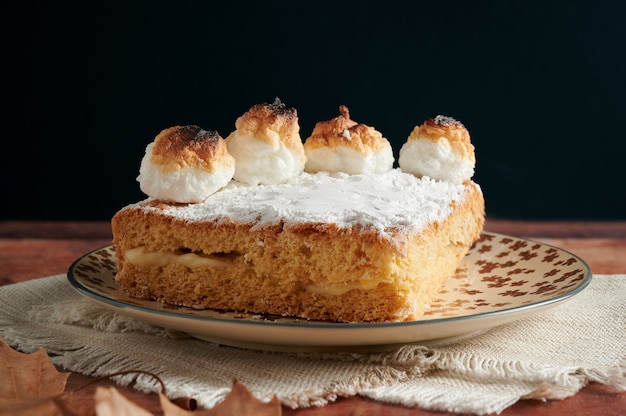 Sponge cake filled with cream and meringue on top.