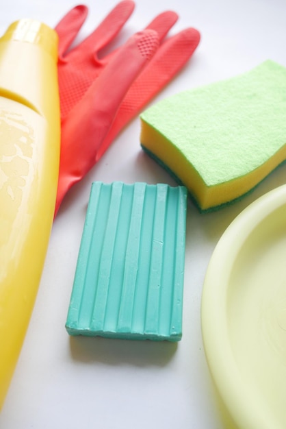 Sponge rubber gloves and colorful plate on pink