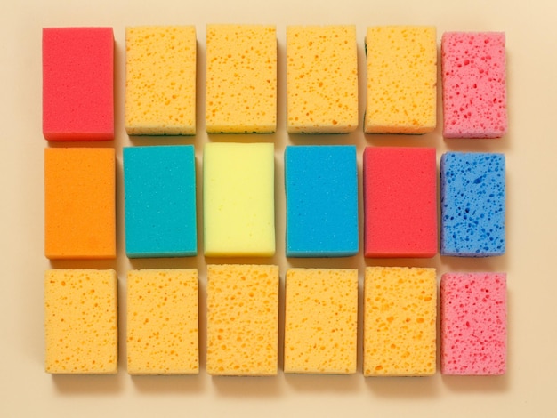 Sponges of different colors on a beige background