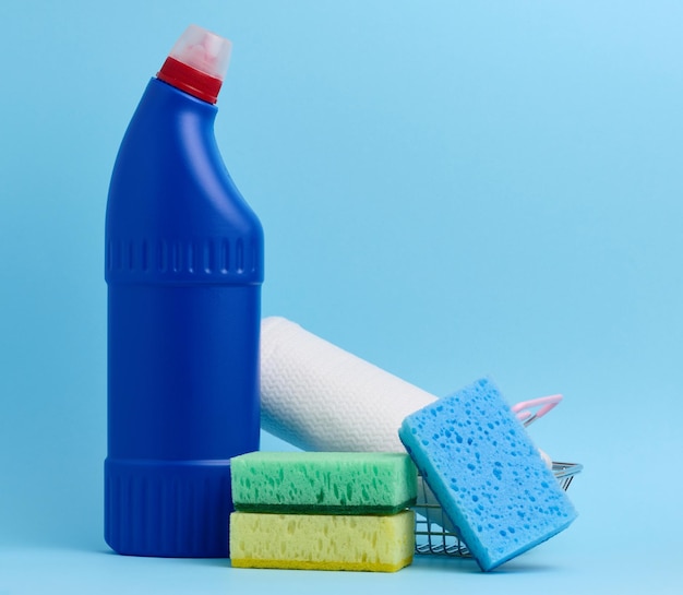 Sponges for the kitchen and a blue bottle with detergent on a blue background