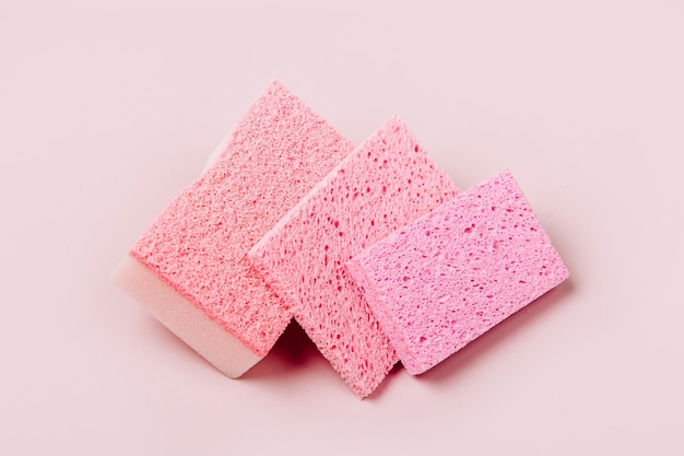 Sponges on pink background. Cleaning or housekeeping concept background. Copy space. Flat lay, Top view.