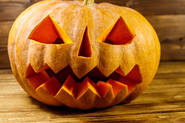 Spooky Halloween pumpkin jackolantern on a wooden background