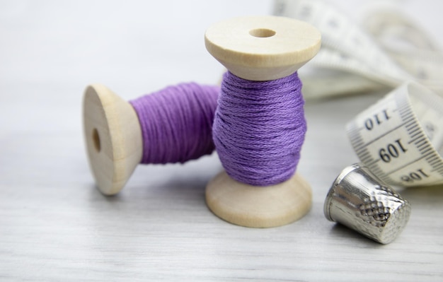 A spool of purple thread on a wooden table Sewing accessories