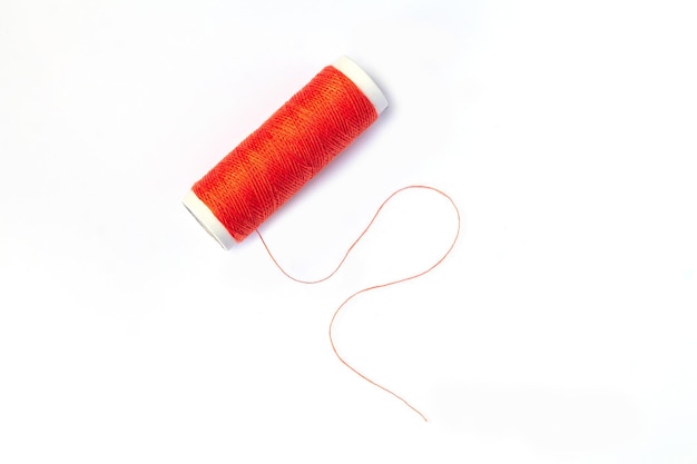 Spool of red thread isolated on white background