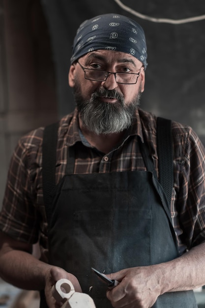 Spoon master in his workshop with wooden products and tools. High quality photo