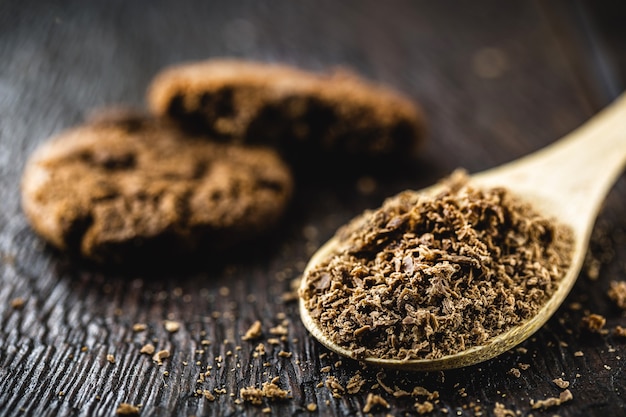 Spoon with grated chocolate, chocolate powder used as cookies ingredient