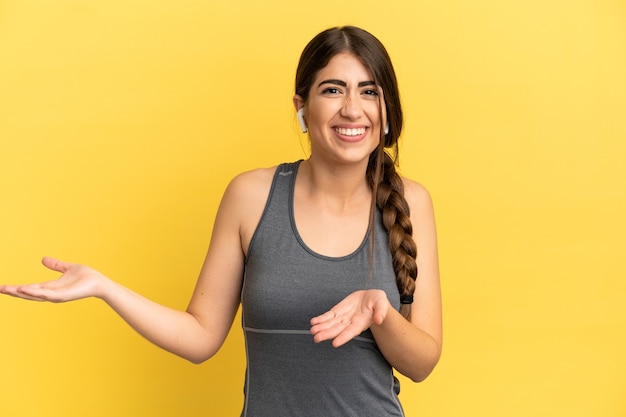 Sport caucasian woman isolated on yellow background with surprise expression while looking side