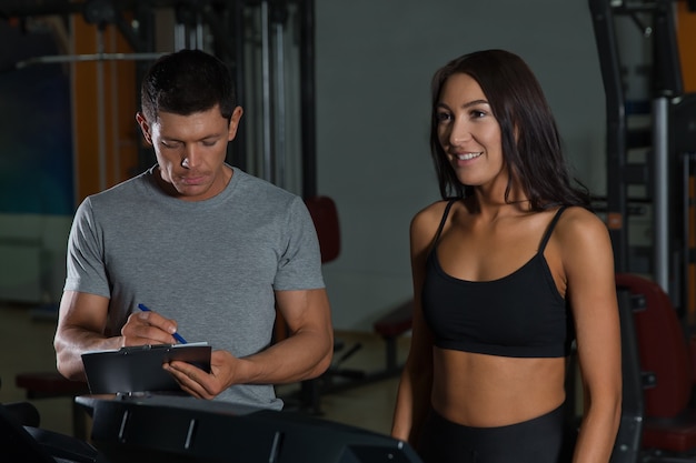 Sport couple on workout in fitness club. Active lifestyle, man and woman in gym